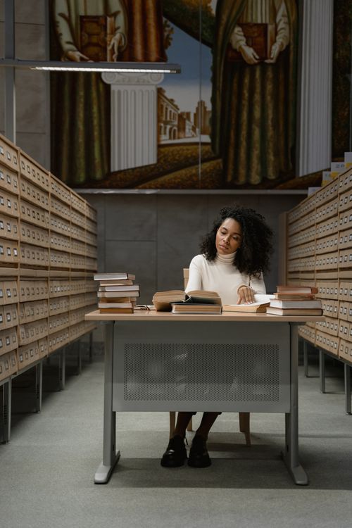 Mujer estudiando con libros — investigación académica con inteligencia artificial