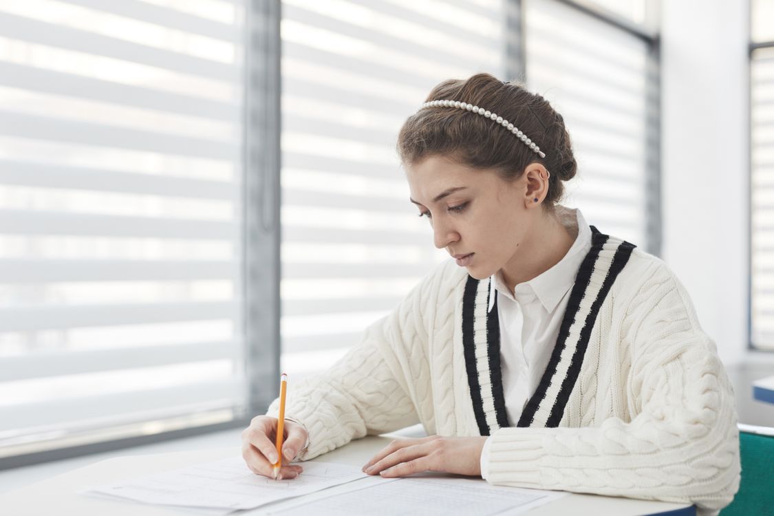 Estudiante haciendo un examen escrito — herramientas de IA para detectar plagio académico